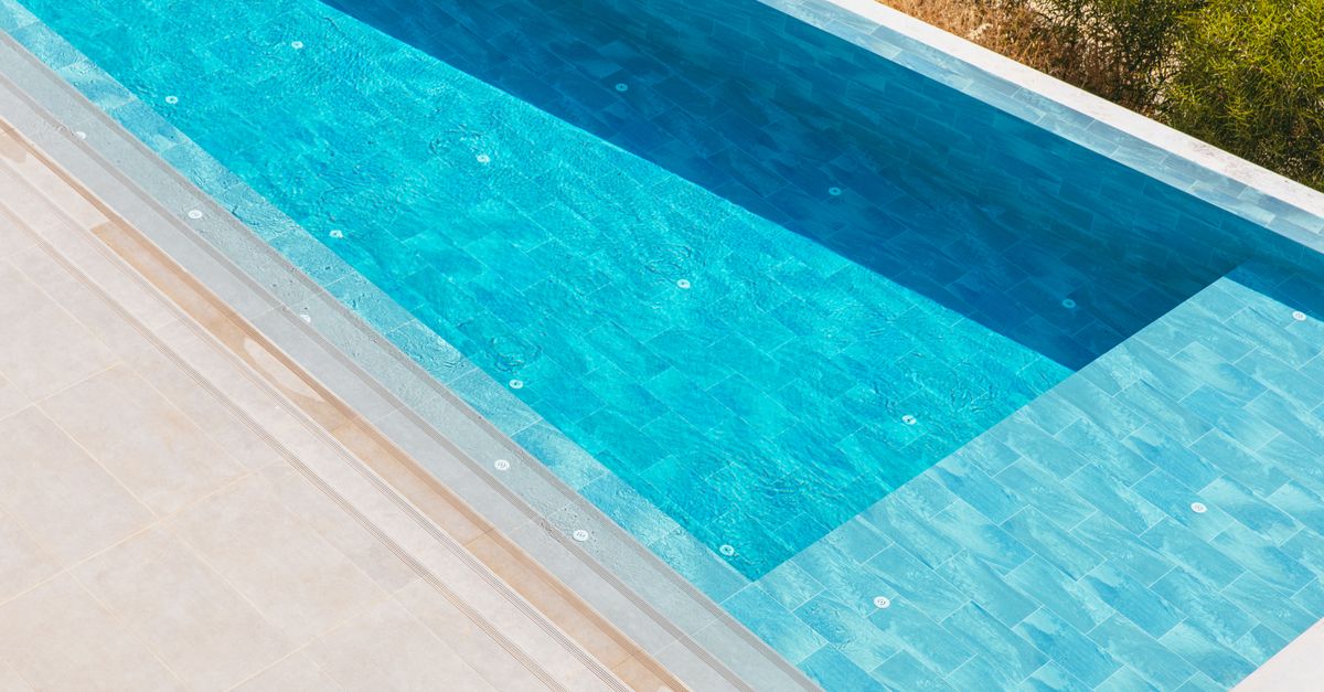 Elegant aerial view of a luxurious swimming pool surrounded by a serene deck. Perfect for summer themes.