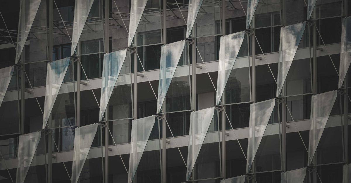 A striking modern building facade showcasing glass panels and geometric patterns, offering a sleek architectural style.