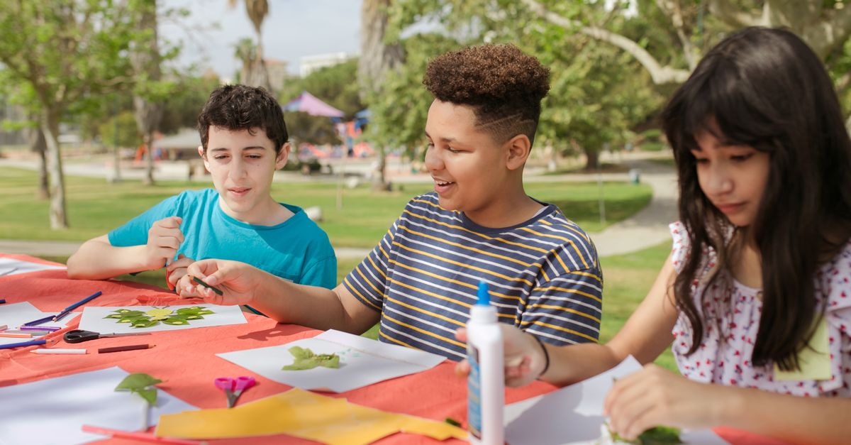 Kids creating art projects at an outdoor summer camp.