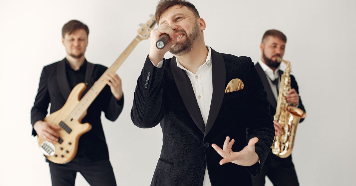 Energetic live band performance featuring musicians playing guitar, saxophone, and singing indoors.