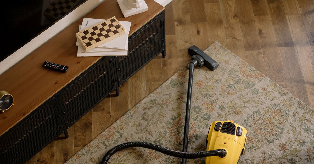 Warm living room scene featuring a yellow vacuum on a floral carpet with a vintage vibe.