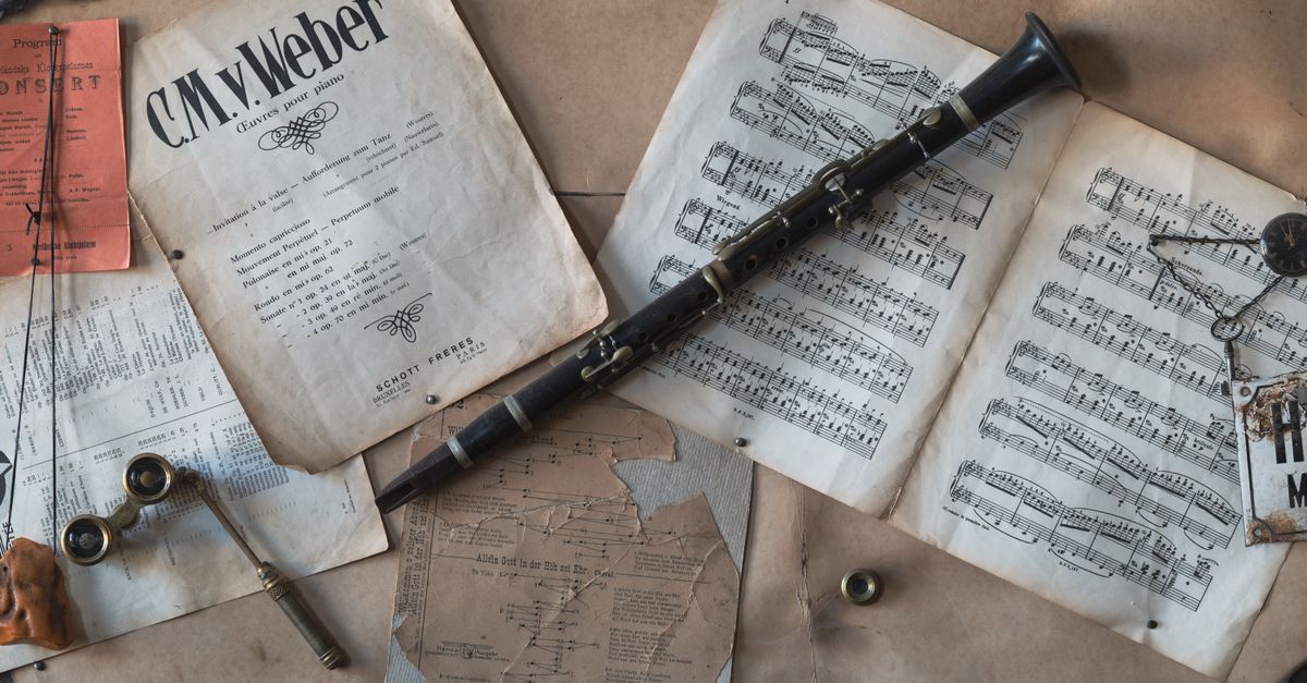 A flat lay of a vintage clarinet with sheet music and antique items, evoking a classic musical vibe.