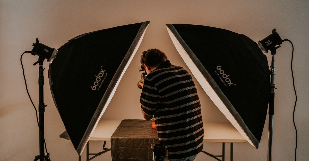 Photographer working in a studio with softbox lighting equipment.