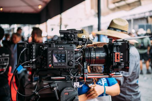 Close-up of a professional video camera setup at an outdoor event focusing on filmmaking equipment.