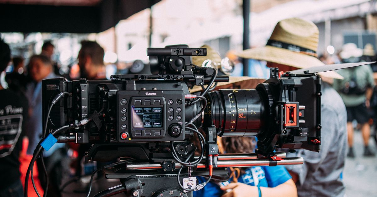 Close-up of a professional video camera setup at an outdoor event focusing on filmmaking equipment.