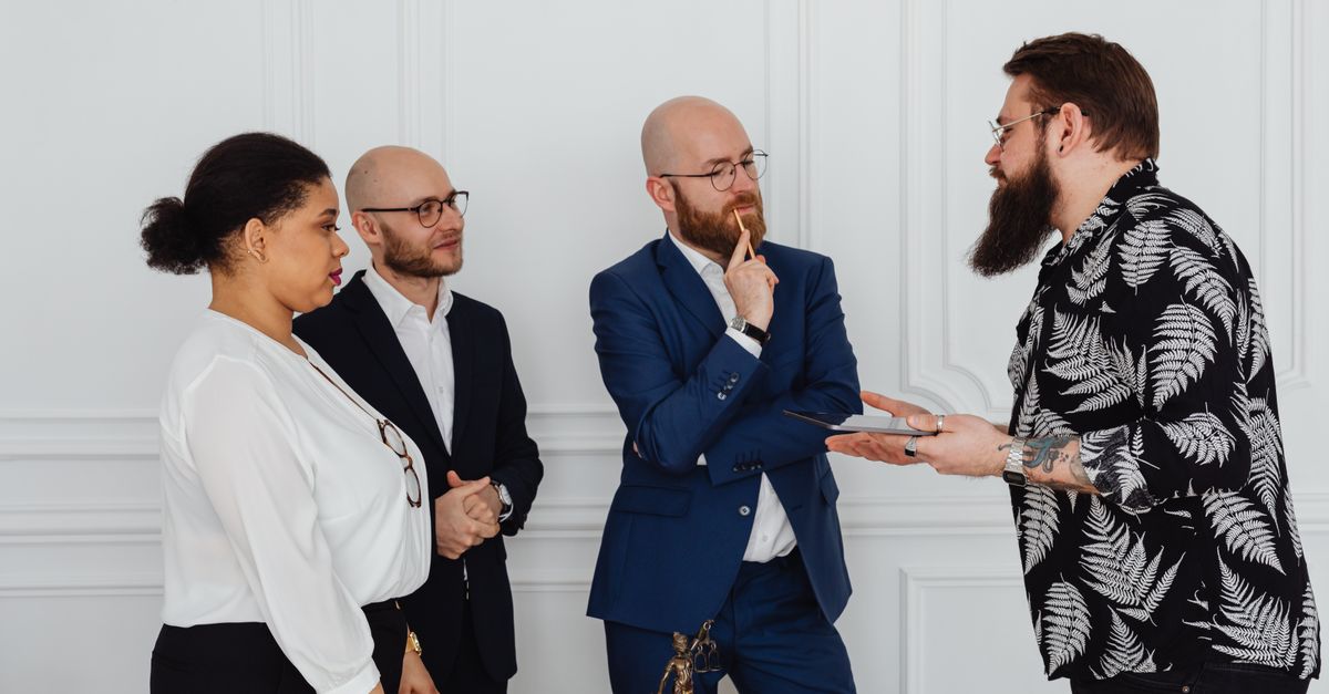 Group of professionals in office discussing documents and ideas during meeting.
