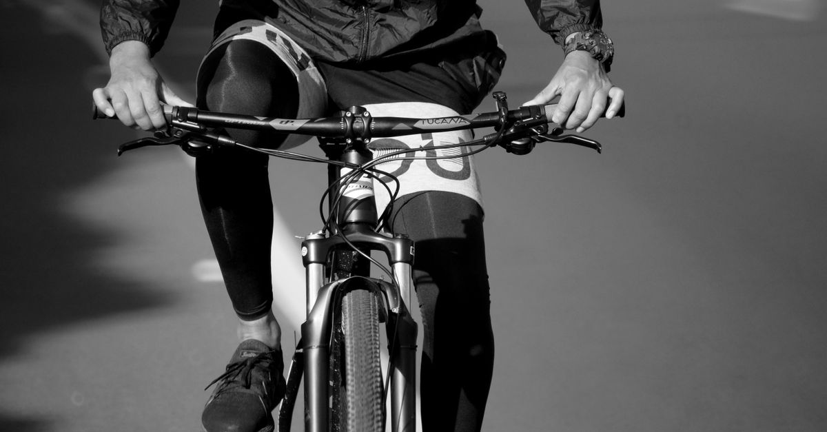A close-up black and white image of a mountain biker in motion, highlighting the sport's dynamic nature.