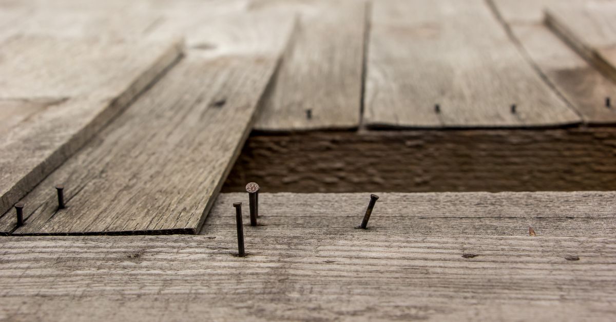 Detailed view of weathered wooden boards and nails, showcasing rustic texture.