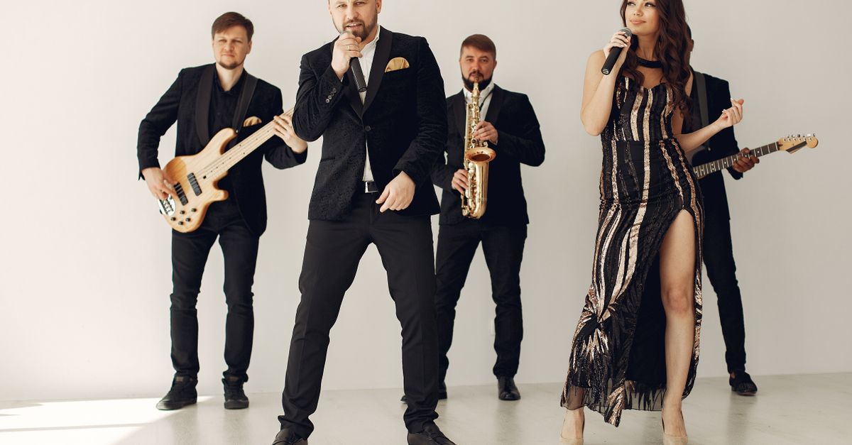 A stylish music band performing with vocalists and musicians in formal attire.