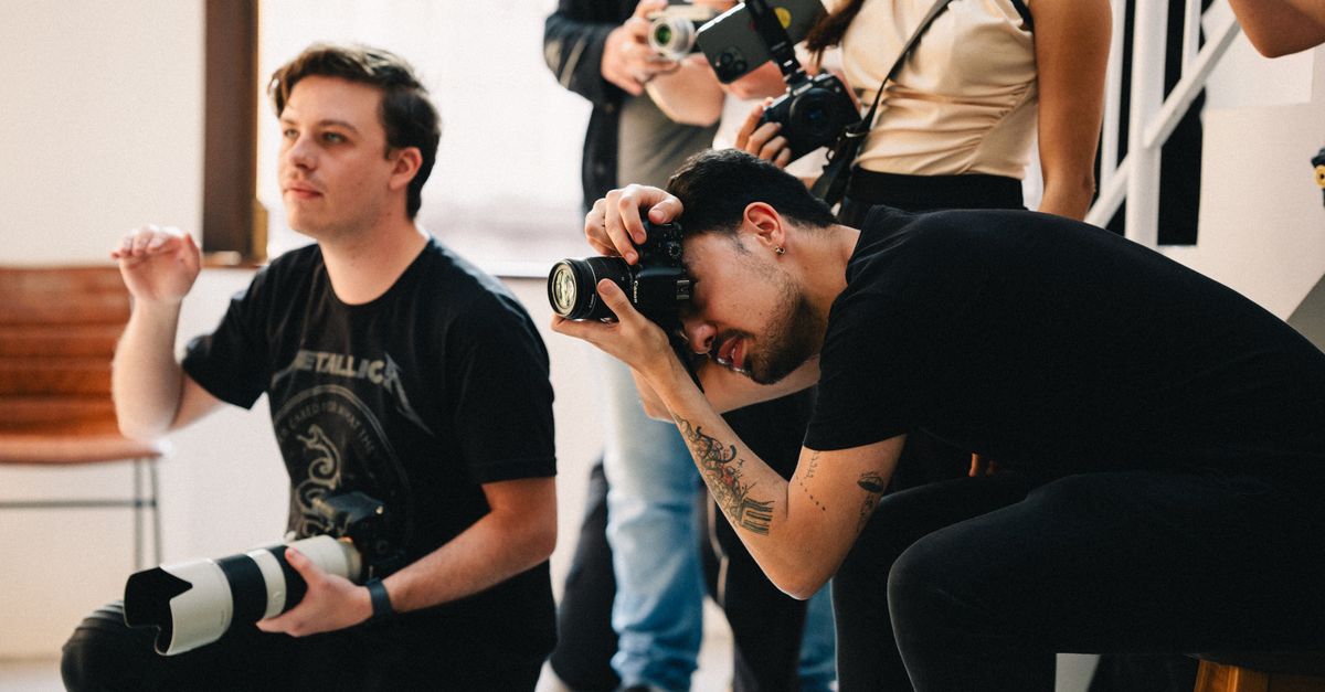Photographers collaborating during an indoor event, capturing professional images.