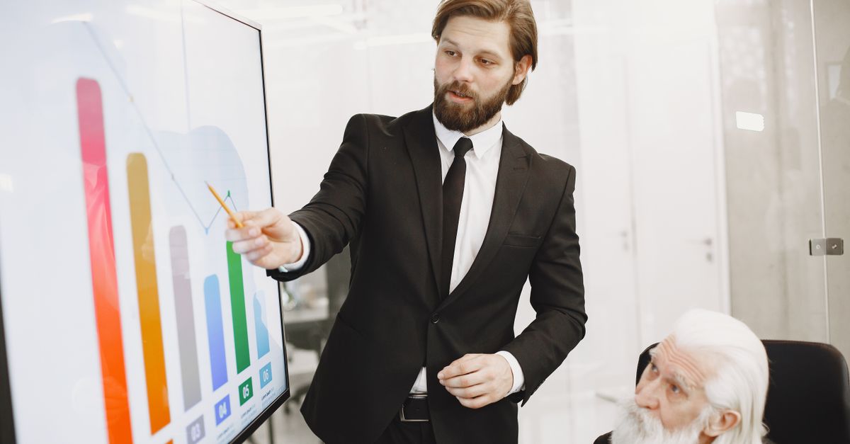 Two businessmen discussing data trends during a presentation in a modern office setting.