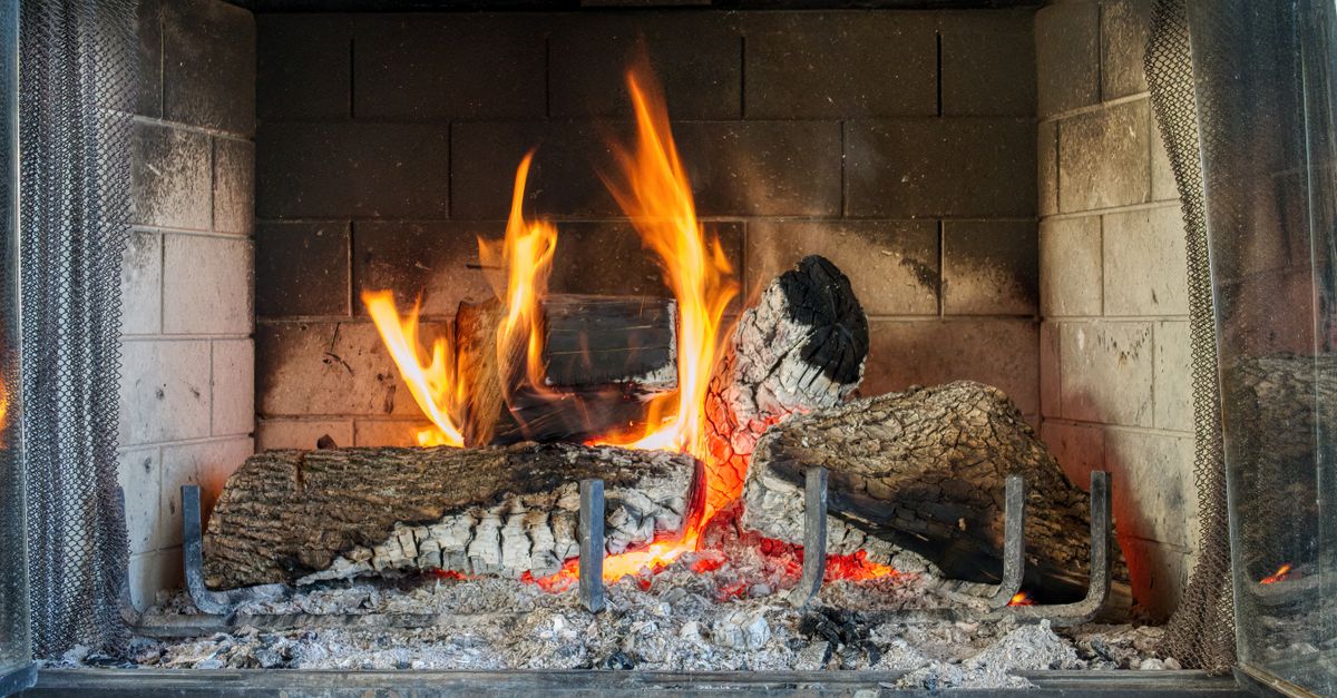 Warm and inviting indoor fireplace with glowing firewood and vibrant flames.