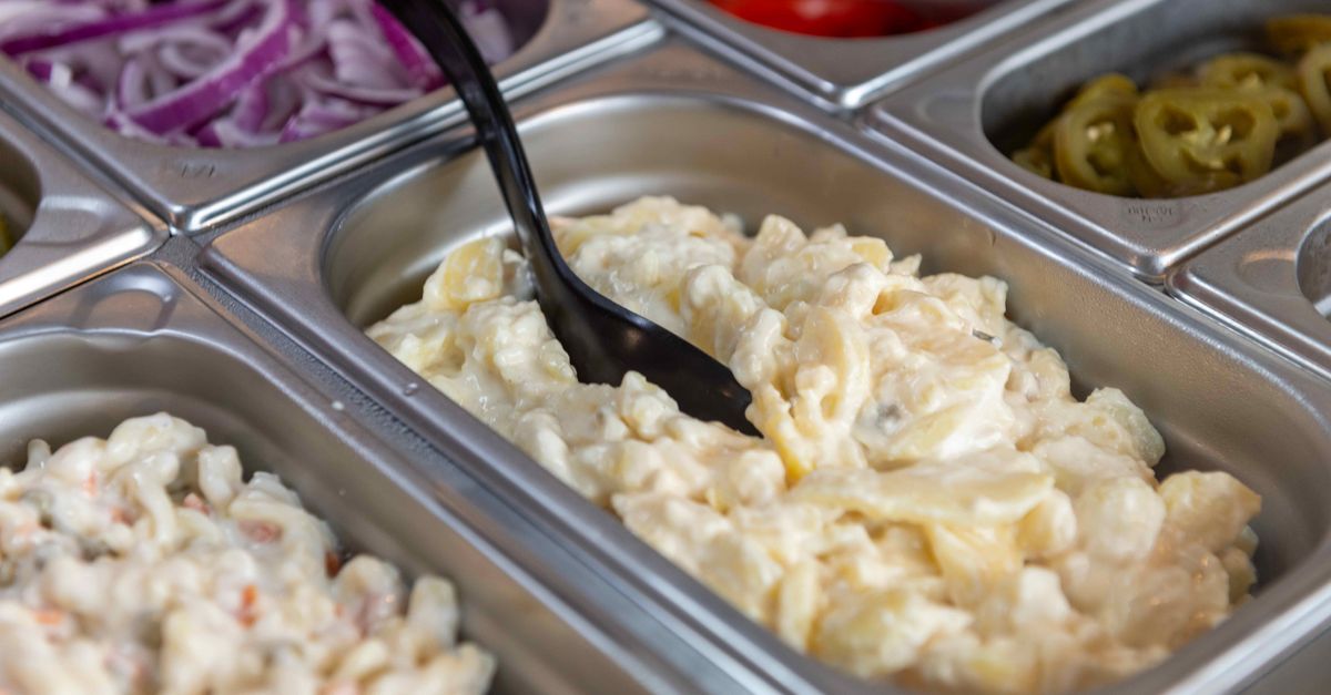 Delicious creamy potato salad ready to serve in a buffet setting. Perfect for lunch or dinner.