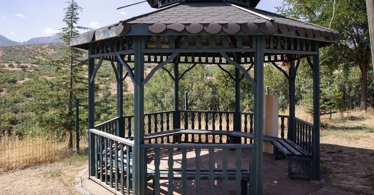 A charming wooden gazebo set amidst the lush greenery of Bingöl, Türkiye, on a sunny day.