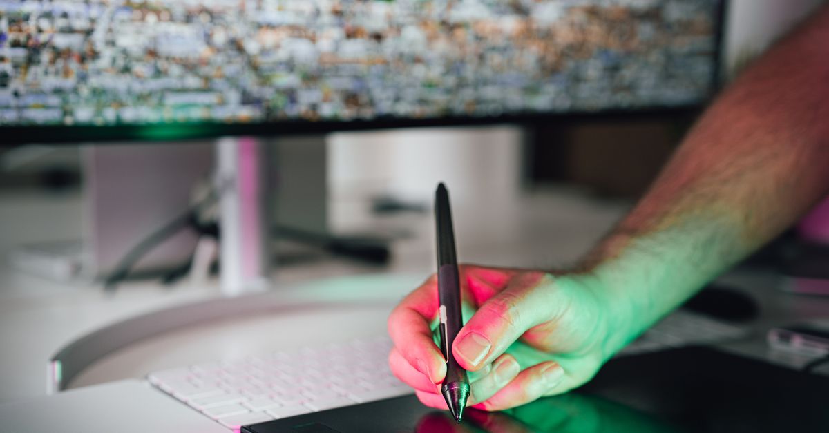 A digital artist using a graphics tablet and stylus in a modern workspace. High-tech creative process.