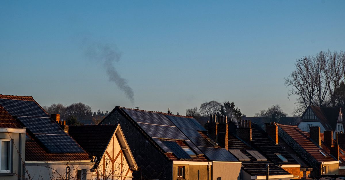 A row of houses displaying solar panels on their rooftops, reflecting sustainable energy practices.