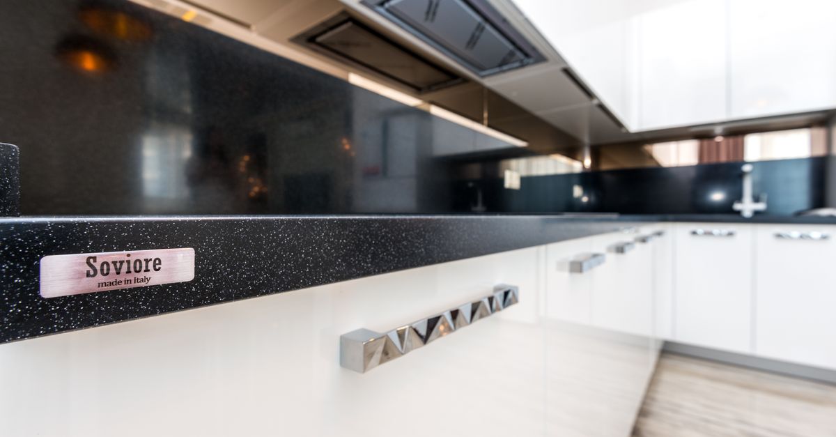 Sleek modern kitchen design featuring white cabinets and Soviore brand details.