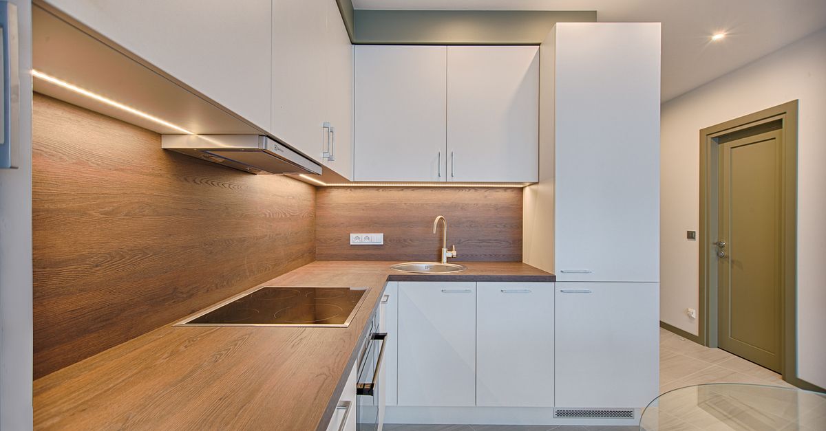 Modern kitchen interior with minimalistic design and wooden accents, captured with natural lighting.