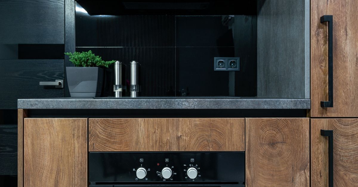 Stylish kitchen interior featuring wooden cabinets, black accents, and modern appliances.