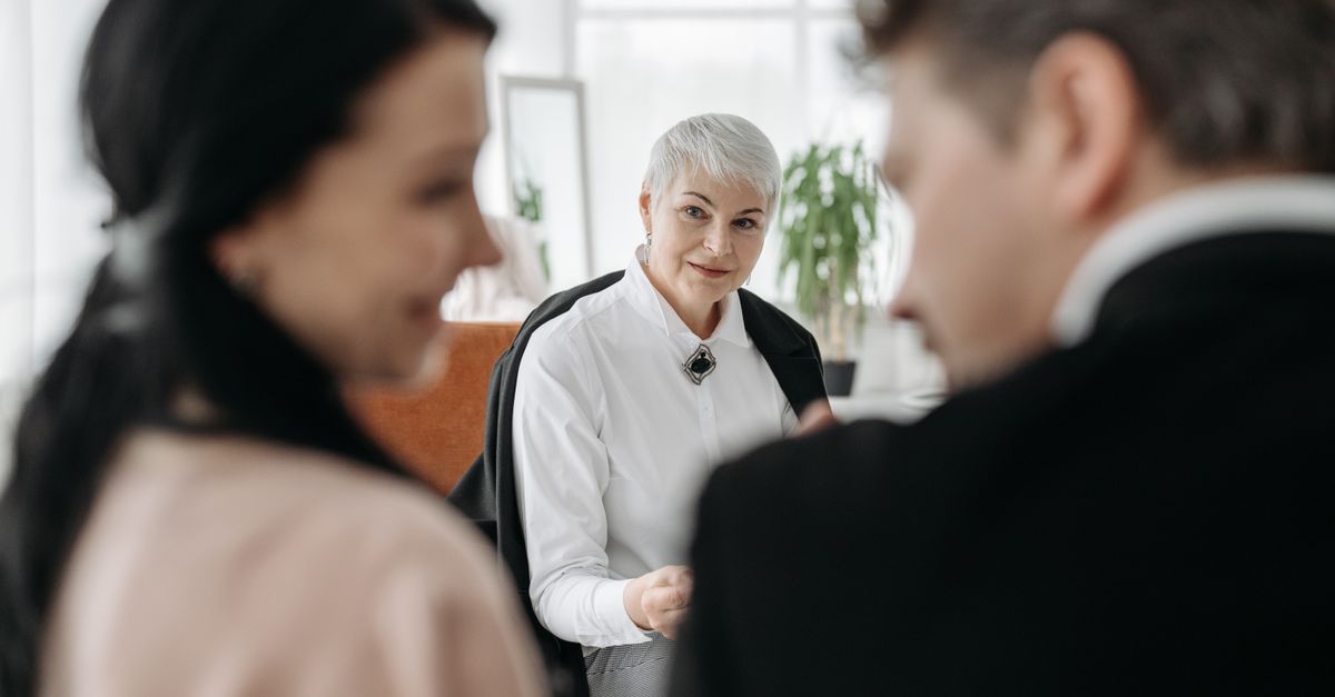 A professional consultation session with a couple and a social worker in a modern office environment.