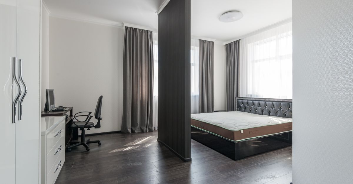 Spacious modern bedroom interior with a minimalist design and home office area.