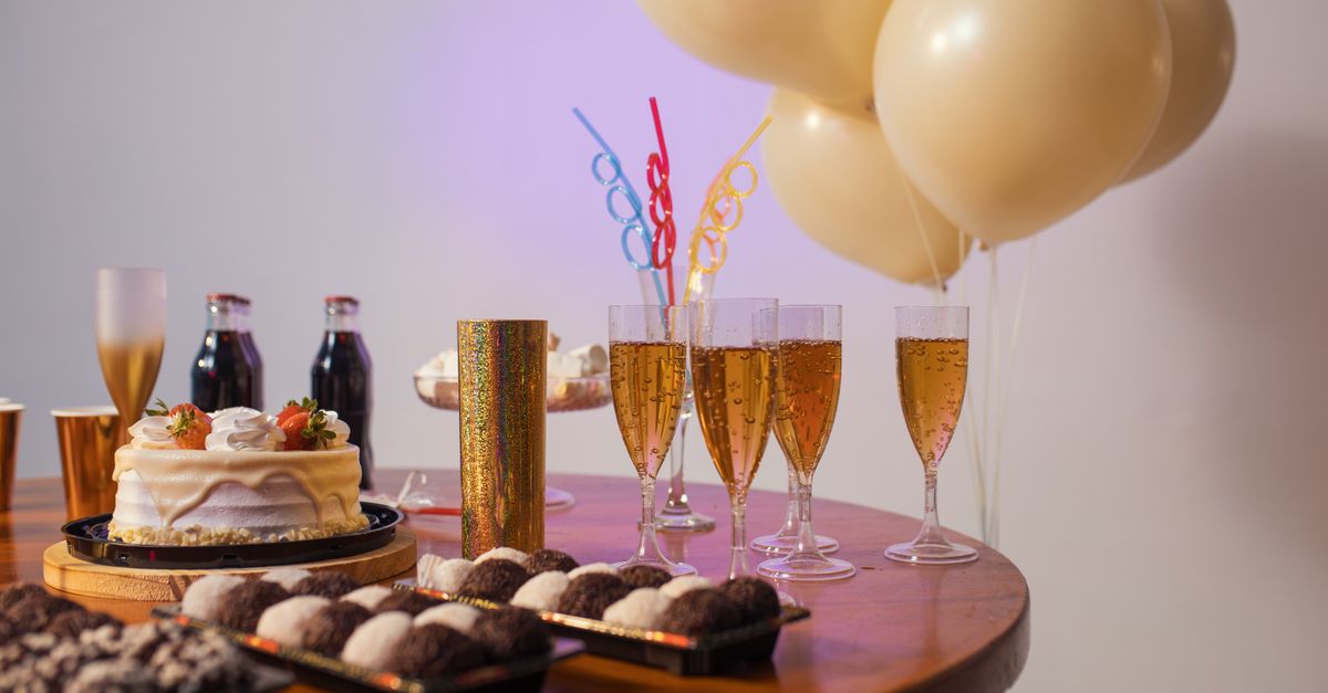 A festive Brazilian table setup with cake, drinks, sweets, and balloons, perfect for any celebration.