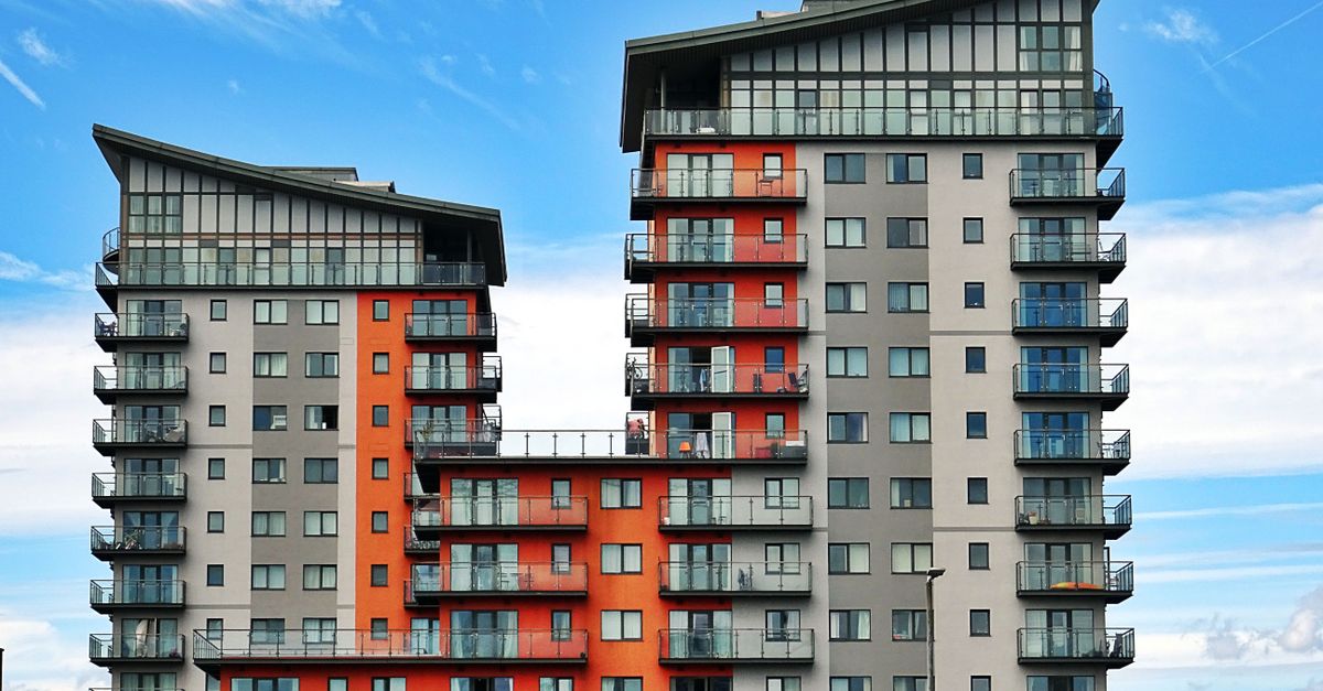 Modern high-rise apartment buildings with unique architecture under a vibrant blue sky.