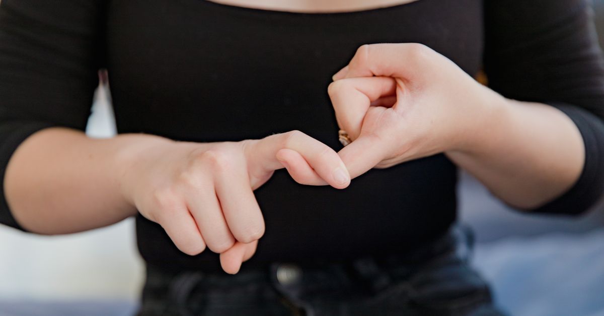 A woman gesturing in sign language, emphasizing non-verbal communication.