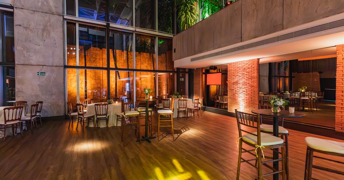 Spacious modern banquet hall with elegant decor and ambient lighting, ready for a celebratory event.