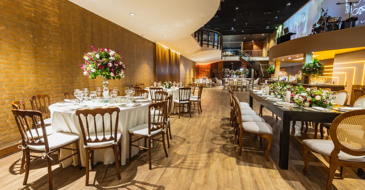 Luxurious wedding hall set for a reception with elegant table arrangements and floral decor.