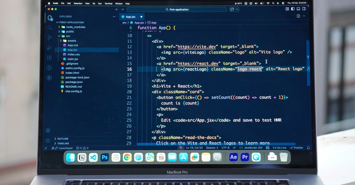 A MacBook Pro displaying code editor on a rooftop setting in daylight, ideal for a remote work lifestyle.