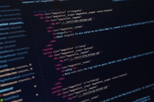 Close-up view of HTML code displayed on a dark screen, showcasing coding concepts.