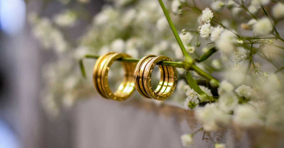 Close-up of shimmering gold wedding bands delicately resting on baby's breath flowers, symbolizing love and commitment.