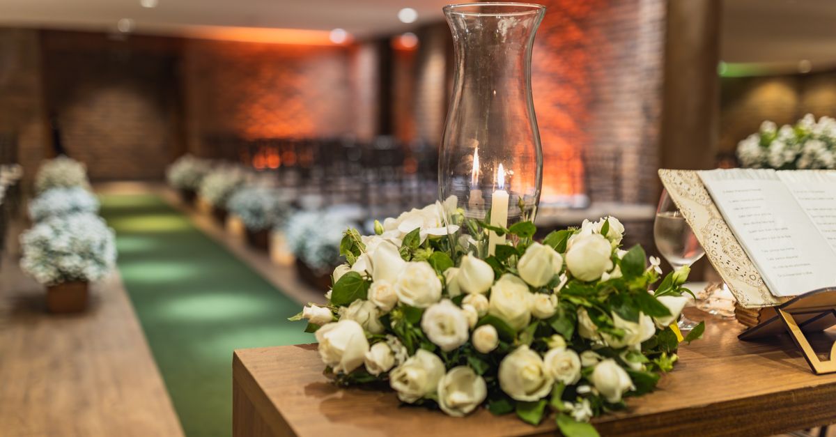 A close-up of a beautiful white rose arrangement at an indoor wedding venue.