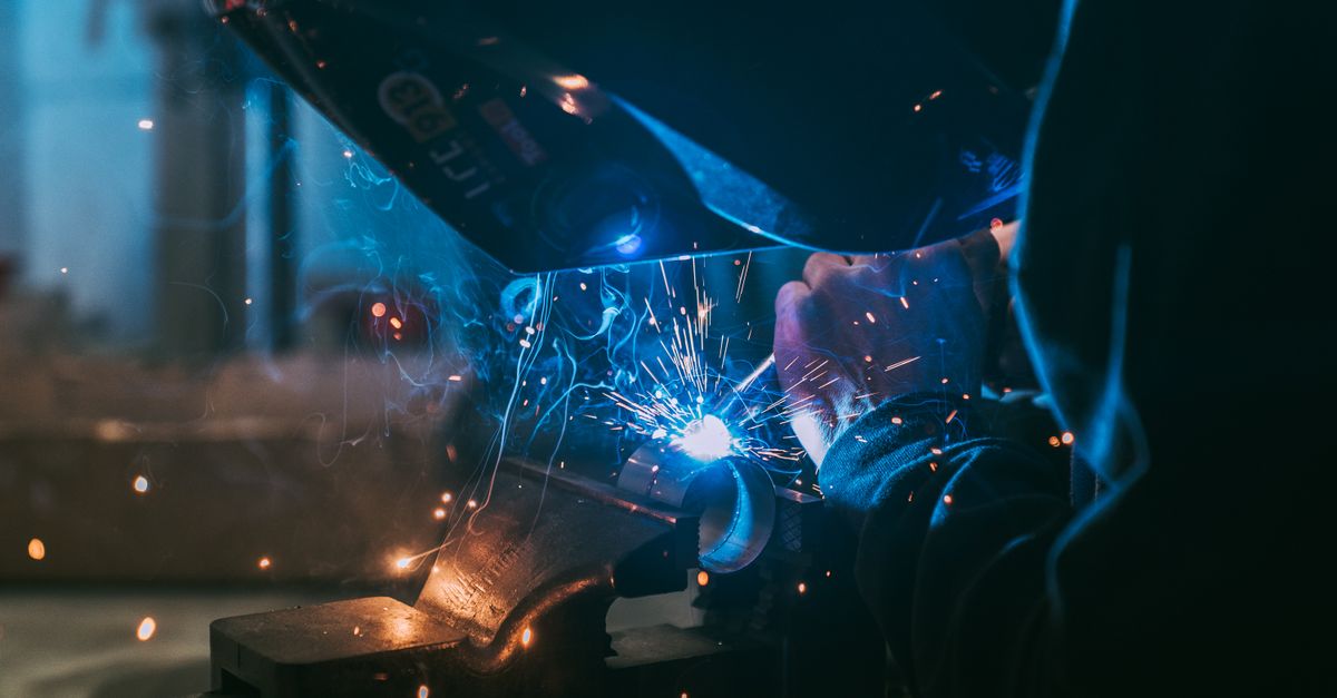 Close-up of a welder working with sparks flying, showcasing industrial craft in Paris.